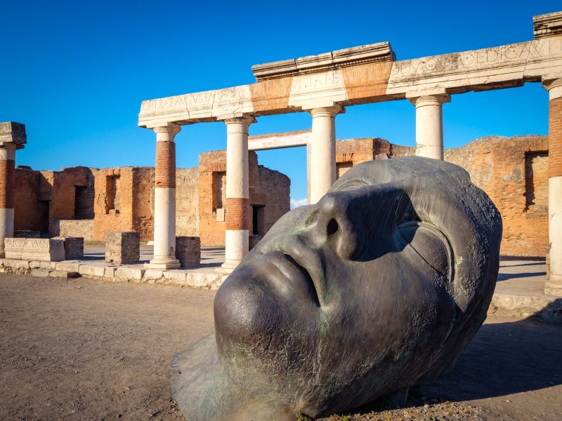 Scenic view of ruins and bronze statue in ancient Pompeii city